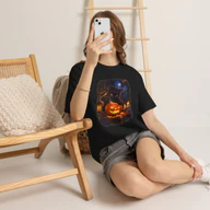Woman wearing a black Black Cat Ninja Carving Pumpkin Halloween T-Shirt while seated indoors